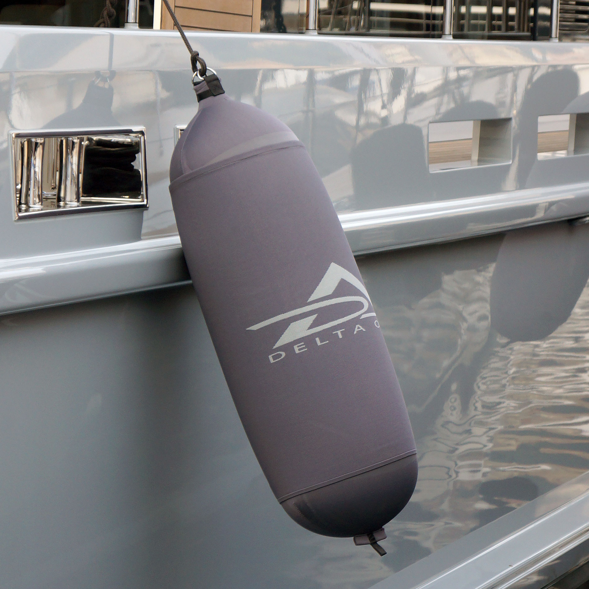 Grey Fendertex cylindrical fender on power boat