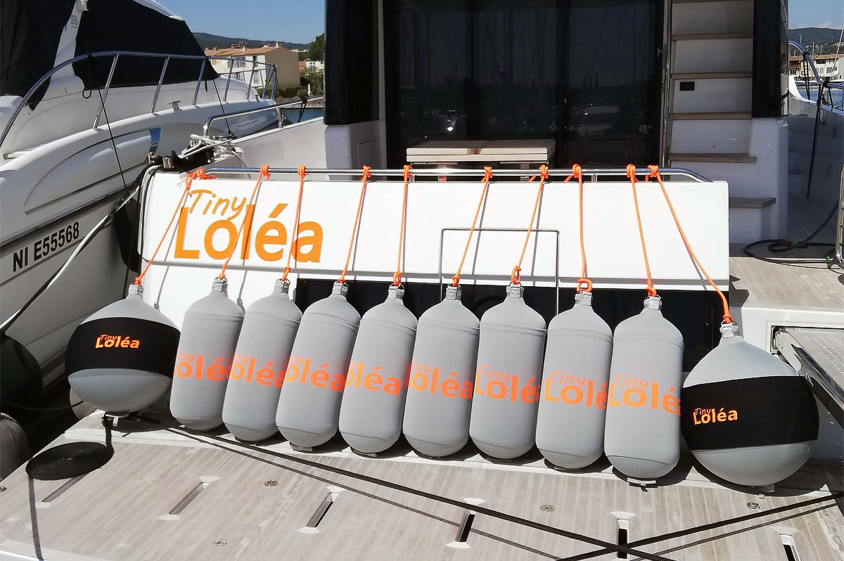 Custom gray and orange Fendertex fenders on powerboat